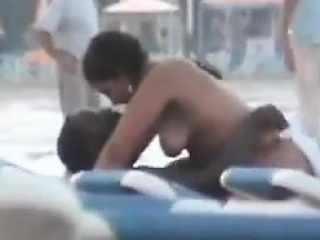 Interracial couple having sex at the beach