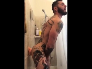 Tatted hunk fucks dildo in shower until he cums